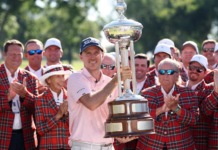 2026 Charles Schwab Challenge: Henley’s Stunning Finish Steals Colonial Crown Golfer in a pink polo and Titleist cap holding a tall silver trophy while cheers erupt from teammates in red plaid jackets behind him.
